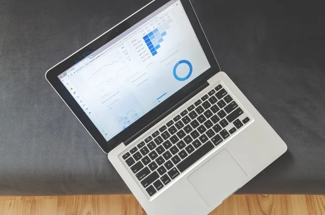 Overhead view of a laptop showing data visualizations and charts on its screen. Why programmatic advertising demand signals matter to English agencies
