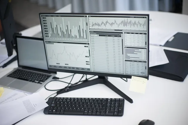 A professional workspace featuring computers and analytical graphs on a monitor, symbolizing modern business environment. When to review programmatic advertising foundations for your agency