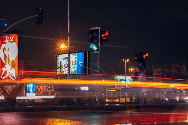 A vibrant city street scene captured at night with long exposure showing traffic lights and light trails. Programmatic advertising risk categories and review sequence for agencies