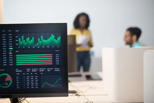 Modern office with financial trading screens and a diverse team discussing strategies. How to compare a managed programmatic service with an in-house licence